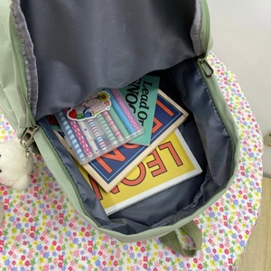 Large capacity light green nylon backpack interior with books and stationery storage space