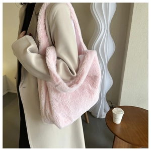 Detail view of soft plush faux fur tote bag in pale pink color worn by model