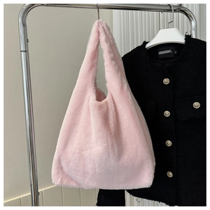 Close-up of soft pink plush tote bag showing fluffy faux fur texture and handle