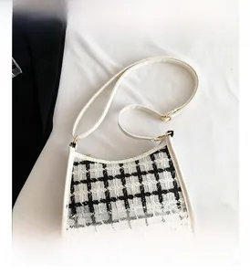 Close-up of black and white plaid tweed small square bag with adjustable leather strap
