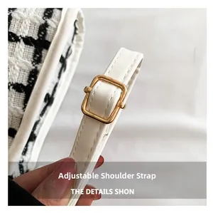 Close-up of adjustable white leather shoulder strap with gold metal buckle on tweed bag