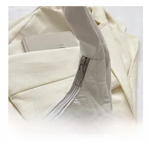 Détail de la fermeture éclair argentée et de la texture matelassée du sac beige