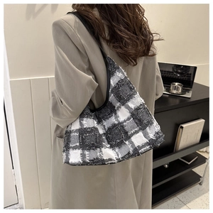 Détail du sac cabas en tweed à carreaux noir et blanc montrant les franges et la texture