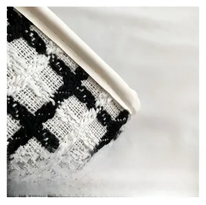 Close-up of black and white checkered tweed fabric with white leather piping detail