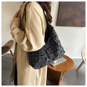 Détail du sac cabas noir à texture écossaise avec finitions franges et bandoulière