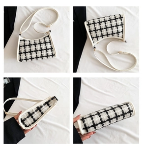 Detail of black and white tweed crossbody bag with white leather trim and gold buckles