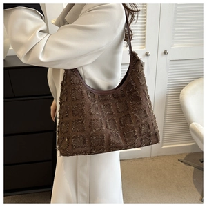 Détail du sac cabas à carreaux marron avec franges rétro et surface en tissu texturé