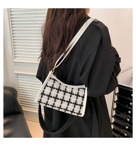 Chic black and white houndstooth tweed crossbody bag worn by a model in a modern interior