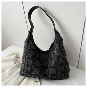 Détail du grand sac cabas noir avec tissu à damier texturé et bandoulière en cuir