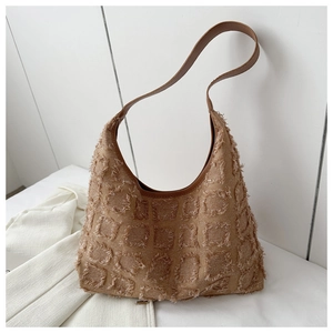 Détail du sac cabas matelassé marron avec bords effilochés et bandoulière en cuir