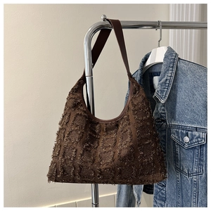 Détail du sac cabas marron foncé avec franges texturées et motif à carreaux