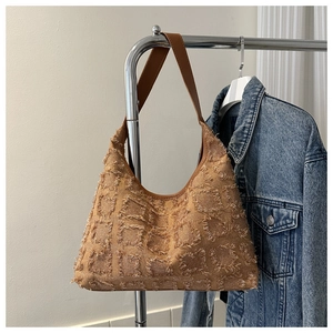 Détail du sac cabas marron avec texture quadrillée à franges et bandoulière en cuir