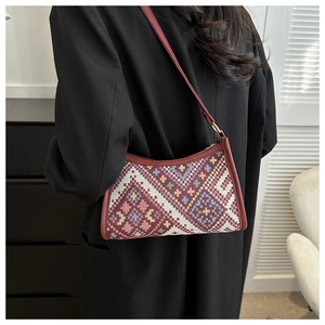 Detailed close-up of a bohemian ethnic woven shoulder bag with geometric patterns