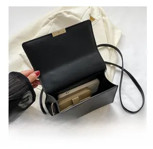 Détail de l'intérieur du sac en cuir noir montrant l'espace pour téléphone et portefeuille