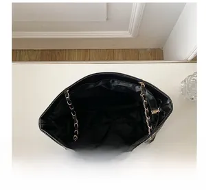 Vue intérieure du sac cabas noir avec compartiment spacieux et chaîne dorée