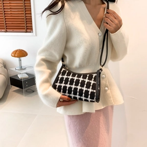 Chic black and white checkered tweed crossbody bag with slim strap shown on model