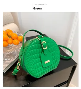Dettaglio borsa circolare verde brillante con trama a rombi in rilievo e placca dorata