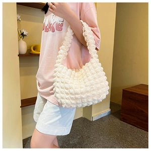 Dettaglio della texture a bolle bianche su una piccola borsa a spalla popcorn alla moda