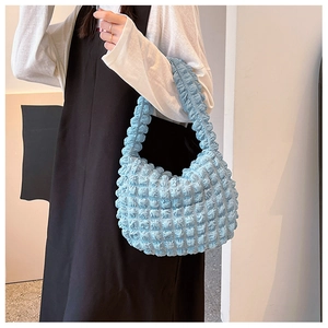 Dettaglio del tessuto testurizzato azzurro su una borsa a spalla alla moda