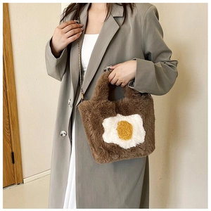 Detail view of brown plush egg bag featuring a gold metal chain strap and soft texture