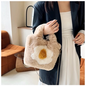 Detailed close-up of a plush egg-shaped handbag with a gold chain strap and soft fuzzy texture