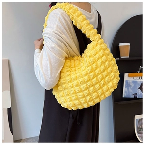 Vista dettagliata della trama a bolle gialla su una borsa a spalla alla moda da donna