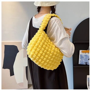 Dettaglio della trama a bolle giallo vivace su una borsa a tracolla elegante da donna