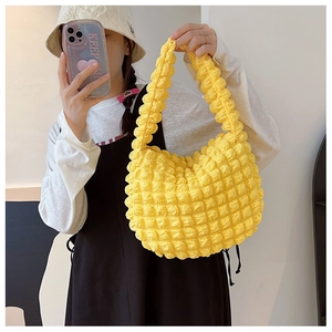 Dettaglio della trama a bolle giallo vivace su una borsa a tracolla alla moda