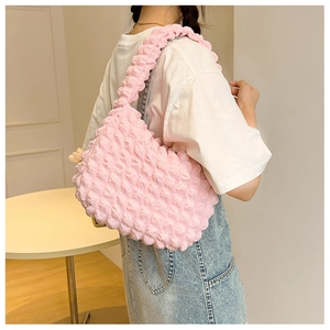 Dettaglio del tessuto rosa con trama a bolle su una borsa a tracolla alla moda