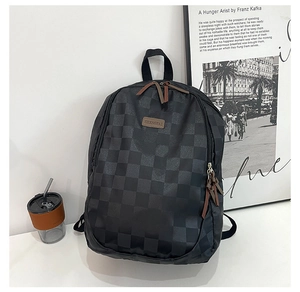 Detail of black checkerboard backpack with brown leather logo and zipper accents