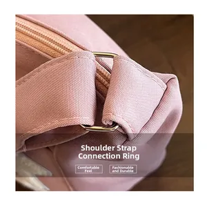 Detail of pink canvas tote bag showing metal strap connector and durable fabric texture