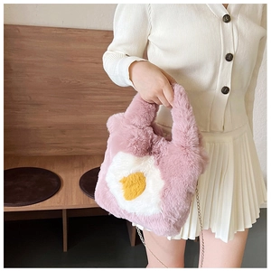 Detail of pink plush crossbody bag featuring fried egg appliqué and gold chain strap