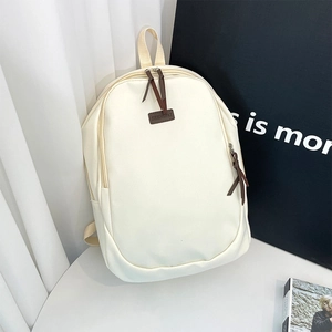 Minimalist cream white canvas backpack with brown leather details for casual commuting style
