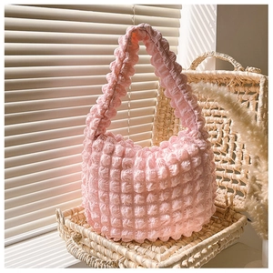 Dettaglio ravvicinato della texture in tessuto popcorn rosa di una piccola borsa hobo