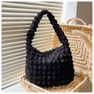 Dettaglio della trama a bolle nera su una borsa a tracolla hobo contemporanea