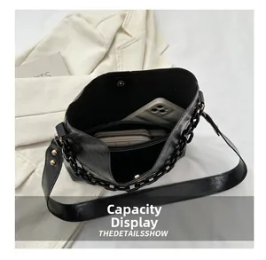 Vista interior del bolso de cubo en cuero negro con gran capacidad y bolsillo