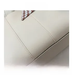 Nahaufnahme einer beigen Shopper-Tasche mit Lychee-Lederstruktur und kariertem Seidenschal