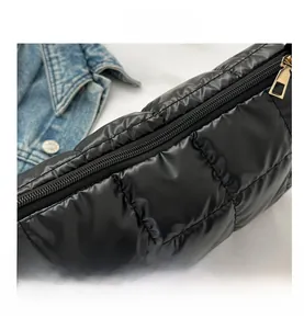 Détail du sac matelassé noir avec fermeture éclair dorée et coutures à carreaux chic