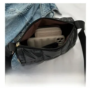 Vue intérieure montrant la grande capacité du sac bandoulière matelassé noir brillant