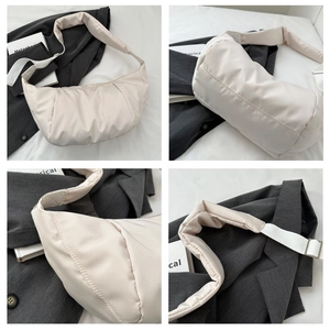 Detail view of the beige puffy nylon shoulder bag with adjustable silver metal buckles