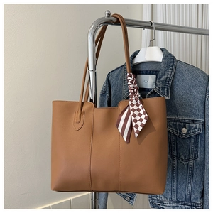 Braune Shopper-Tasche aus Kunstleder am Kleiderbügel mit dekorativem gestreiftem Seidentuch