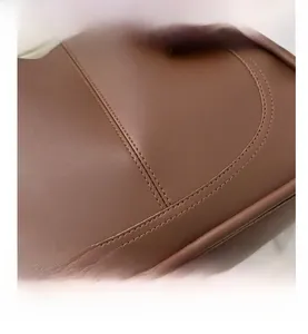 Close-up of brown faux leather texture and durable double-stitched seams on the tote bag