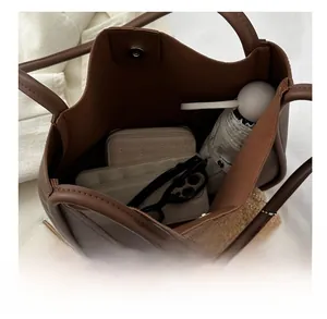 Top-down view showing spacious interior and items inside the brown leather tote bag