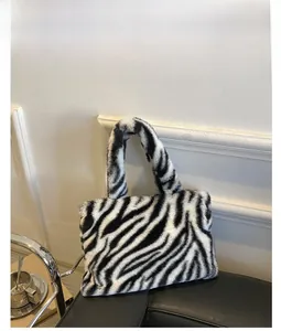 Detail view of high-quality zebra pattern plush tote bag on a dark leather surface