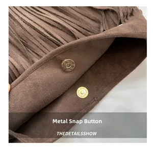 Detail view of large brown suede tote featuring gold magnetic snap and tassel fringe trim