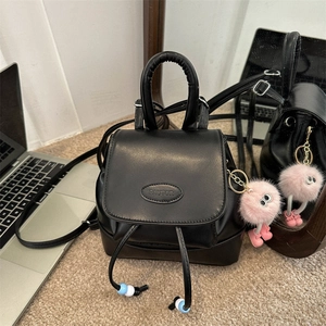 Mini mochila minimalista de cuero PU negro con lindo colgante de felpa rosa para mujeres