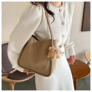 Khaki faux leather tote bag with U-shaped stitching and cute brown plush bear charm