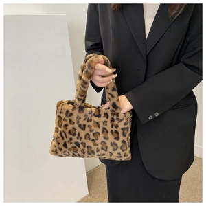 Detail view of plush leopard print handbag with soft faux fur texture and top handles