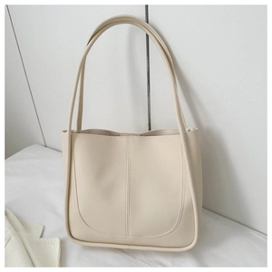 Detail of off-white PU leather tote bag featuring unique U-shaped stitching and slim straps
