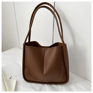 Detailed close-up of brown PU leather tote bag with central vertical stitching detail